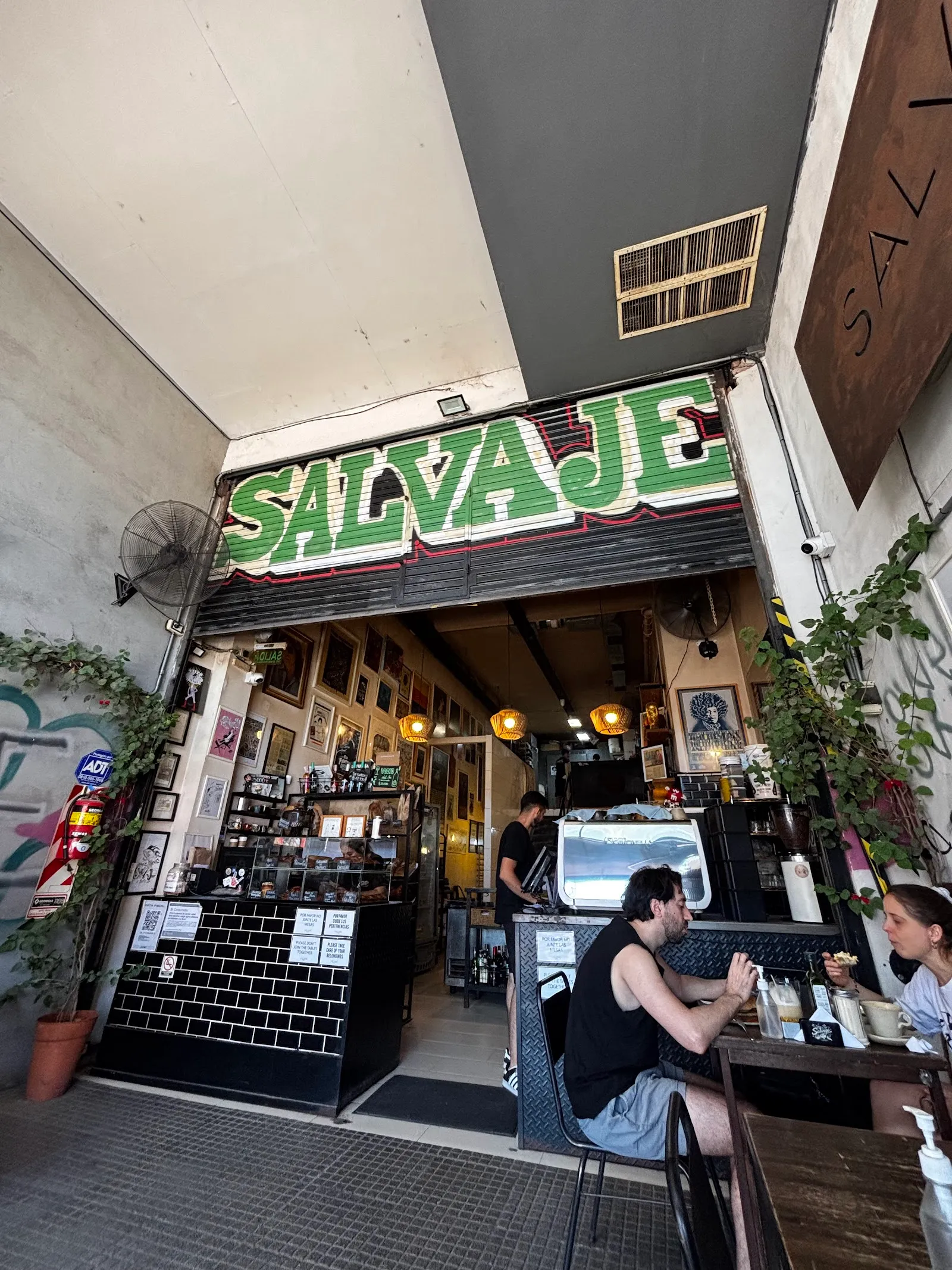 Frente de Salvaje Bakery con el cartel verde y gente en la vereda